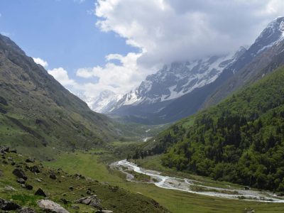Stunning Himalayan valley with lush green meadows and snow-capped peaks.