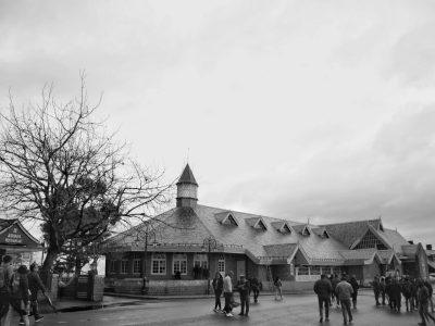 Monochrome photo of a historic building with tourists in Shimla, India, showcasing colonial architecture.