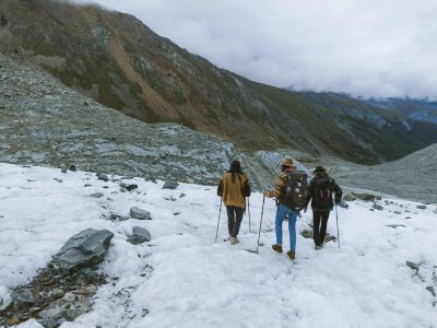 Three hikers traverse a snow-covered mountain in winter, showcasing adventure.